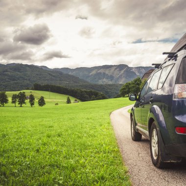 car for traveling with a mountain road. Dramatic sky