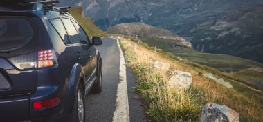 car for traveling with a mountain road. Dramatic sky