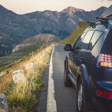 car for traveling with a mountain road. Dramatic sky