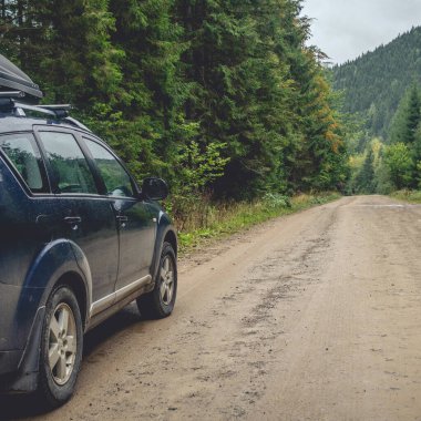 car for traveling with a mountain road. Dramatic sky