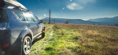 car for traveling with a mountain road. Dramatic sky