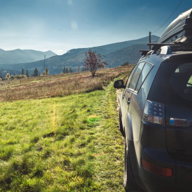 car for traveling with a mountain road. Dramatic sky