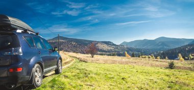 car for traveling with a mountain road. Dramatic sky