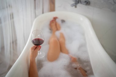 Kırmızı ayakkabılı ve bir bardak şaraplı kadın bacakları, otel.