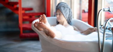 Otel odasında bornozlu kadın ayakları, yakın plan.