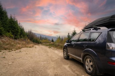 car for traveling with a mountain road. Dramatic sky