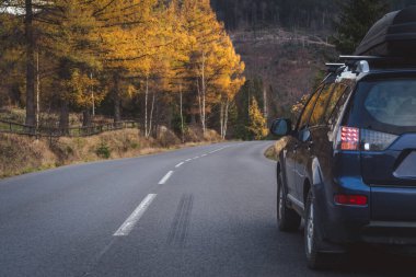 car for traveling with a mountain road. Dramatic sky