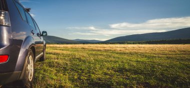 Woman in white bathrobe lying on sofa and relaxing with orange cocktail at the roof of hotel