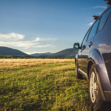 Woman in white bathrobe lying on sofa and relaxing with orange cocktail at the roof of hotel