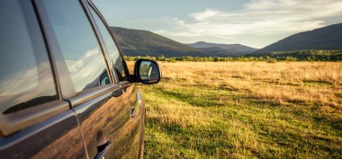 Woman in white bathrobe lying on sofa and relaxing with orange cocktail at the roof of hotel