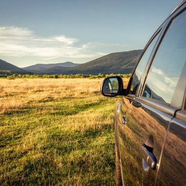 Woman in white bathrobe lying on sofa and relaxing with orange cocktail at the roof of hotel