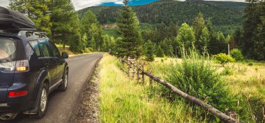 Woman in white bathrobe lying on sofa and relaxing with orange cocktail at the roof of hotel