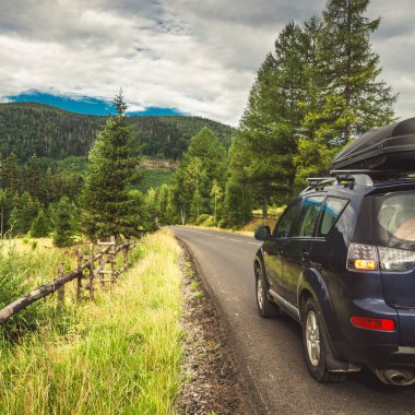 Woman in white bathrobe lying on sofa and relaxing with orange cocktail at the roof of hotel