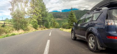Woman in white bathrobe lying on sofa and relaxing with orange cocktail at the roof of hotel