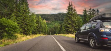 Woman in white bathrobe lying on sofa and relaxing with orange cocktail at the roof of hotel