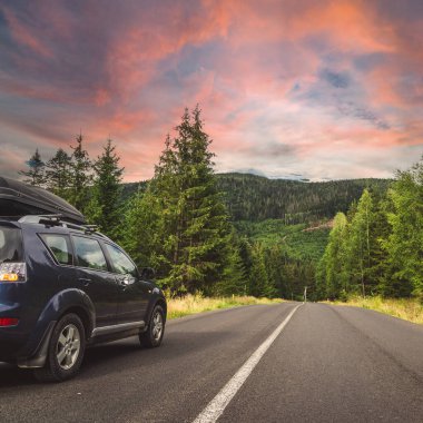 Woman in white bathrobe lying on sofa and relaxing with orange cocktail at the roof of hotel