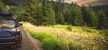 Woman in white bathrobe lying on sofa and relaxing with orange cocktail at the roof of hotel
