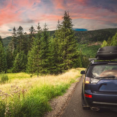 Woman in white bathrobe lying on sofa and relaxing with orange cocktail at the roof of hotel
