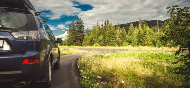 Woman in white bathrobe lying on sofa and relaxing with orange cocktail at the roof of hotel
