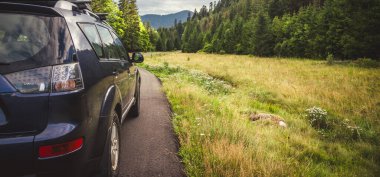 Woman in white bathrobe lying on sofa and relaxing with orange cocktail at the roof of hotel