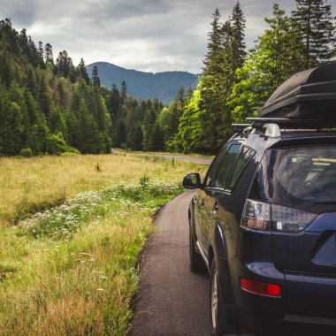 Woman in white bathrobe lying on sofa and relaxing with orange cocktail at the roof of hotel