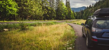 Woman in white bathrobe lying on sofa and relaxing with orange cocktail at the roof of hotel