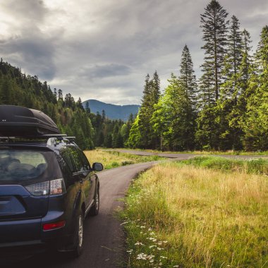 Woman in white bathrobe lying on sofa and relaxing with orange cocktail at the roof of hotel