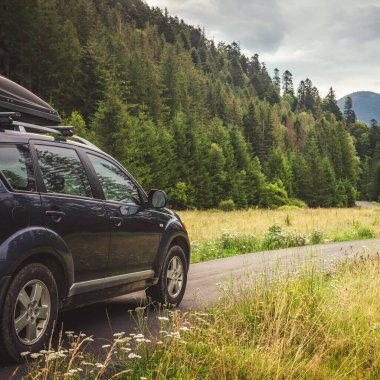 Woman in white bathrobe lying on sofa and relaxing with orange cocktail at the roof of hotel