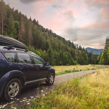 Woman in white bathrobe lying on sofa and relaxing with orange cocktail at the roof of hotel