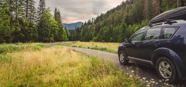 Woman in white bathrobe lying on sofa and relaxing with orange cocktail at the roof of hotel