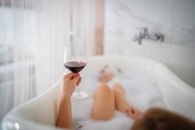 Kırmızı ayakkabılı ve bir bardak şaraplı kadın bacakları, otel.