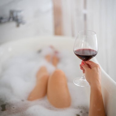 Kırmızı ayakkabılı ve bir bardak şaraplı kadın bacakları, otel.