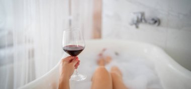 Kırmızı ayakkabılı ve bir bardak şaraplı kadın bacakları, otel.