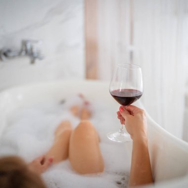 Kırmızı ayakkabılı ve bir bardak şaraplı kadın bacakları, otel.