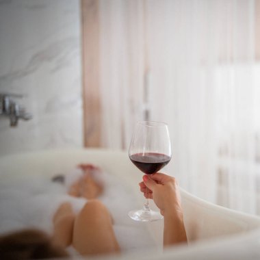 Kırmızı ayakkabılı ve bir bardak şaraplı kadın bacakları, otel.