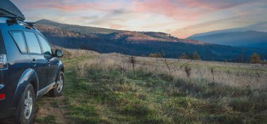 car for traveling with a mountain road. Dramatic sky