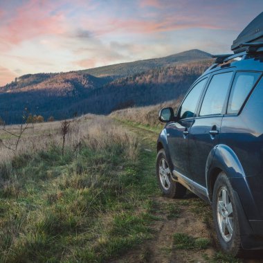car for traveling with a mountain road. Dramatic sky