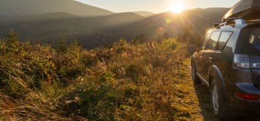 car for traveling with a mountain road. Dramatic sky