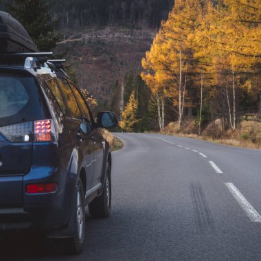 car for traveling with a mountain road. Dramatic sky
