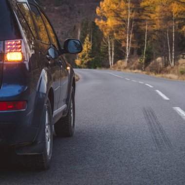 car for traveling with a mountain road. Dramatic sky