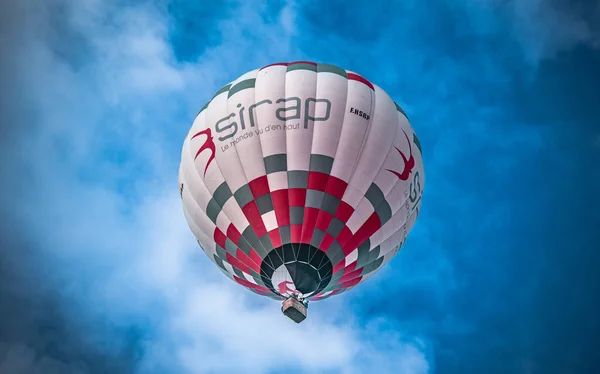 Montgolfiere colore flottant dans un ciel bleu.
