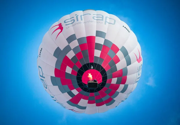 Montgolfiere colore flottant dans un ciel bleu.