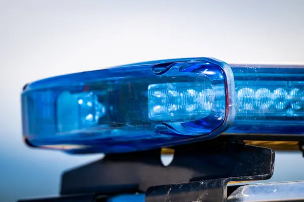 Mavi polis arabası ışık fenerini gösteren detaylı bir resim, acil durum ekipmanlarını vurguluyor.