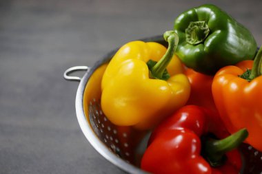 Kevgir ağacının arka planında renkli dolma biberler, yakın plan.