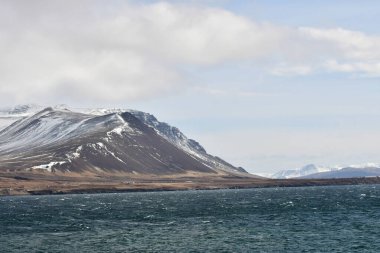İzlanda. Kara, dağların zirveleri ve buzulların oyduğu derin körfezler olan fiyortlarla işaretlenmiş bir kıyı şeridi ile platodur.. 