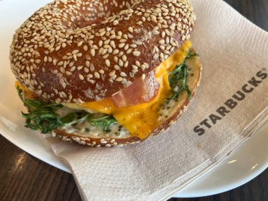 NUREMBERG, ALMANY - 17 Mayıs 2023: Starbucks 'ta geleneksel Alman simidiyle kahvaltı burgeri