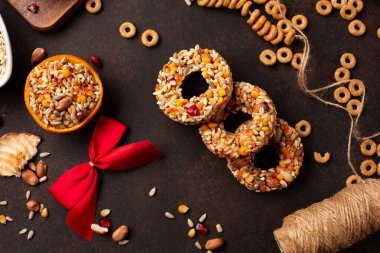 Ev yapımı kuş yemi köfteleri, koyu ahşap arka planda kuşlar için kış yemeği, üst manzara. Kurutulmuş tahıllar kuş yemi, ayçiçeği tohumu - enerji kuşu yağı topları.