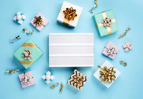 圣诞贺卡 白色的空灯箱 金色和银色装饰 蓝色背景的礼品盒 圣诞节 新年的概念 平面布局 顶视图 复制空间 — 图库照片