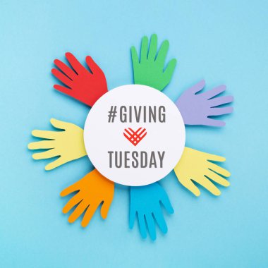 Salı günü, Kara Cuma alışveriş gününden sonra küresel bağış günü. Bağış, yardım, bağış destek konsepti. Mavi arkaplanda renkli eller ve kırmızı kalp, kopyalama alanı, üst görünüm.