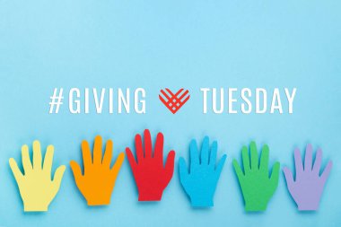 Giving Tuesday, global day of charitable giving after Black Friday shopping day. Charity, give help, donations support concept. Colorful hands and red heart on blue background, copy space, top view. clipart